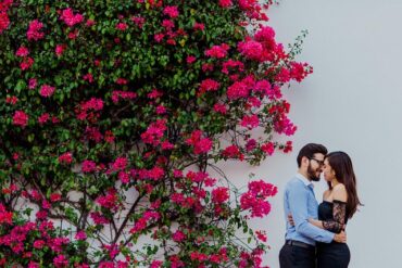 Couple kissing near pink flowers