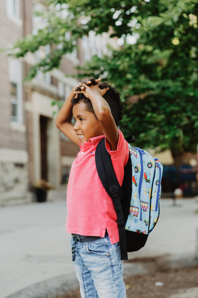 Young boy looking left with backpack