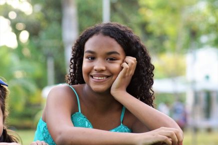 Black girl smiling with hand on face