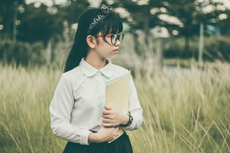 Asian student in field with glasses