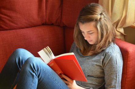 Female reading book on couch