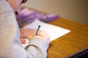 Girl writing on IEP document