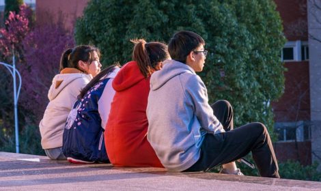 Four teens sitting together with backs to camera