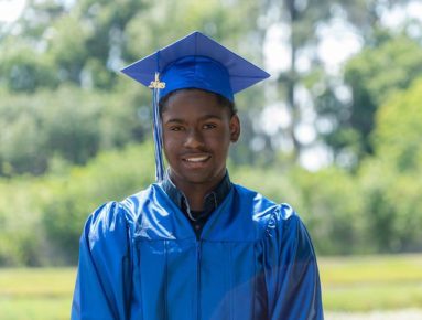 Young black graduate in blue cap and gown