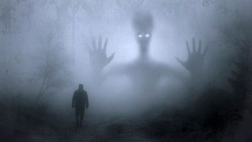 Black and white photo of male walking with giant scary figure above him