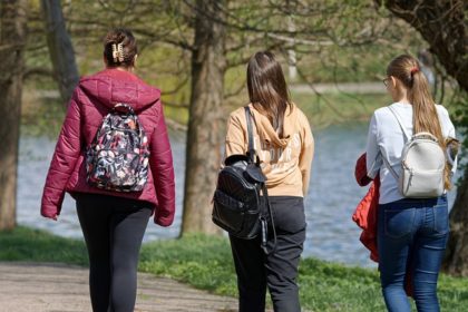 hree females walking away with backpacks