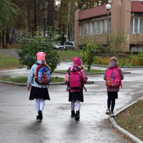 Backs of 3 girls with backpacks