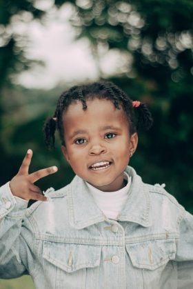 Young Black girl giving peace sign