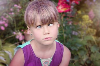 Young girl with crossed eyes looking confused