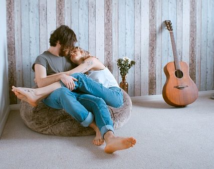 Man and young woman hugging on floor