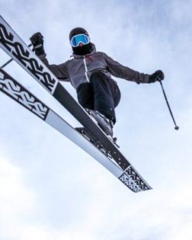 Female skier jumping over camera