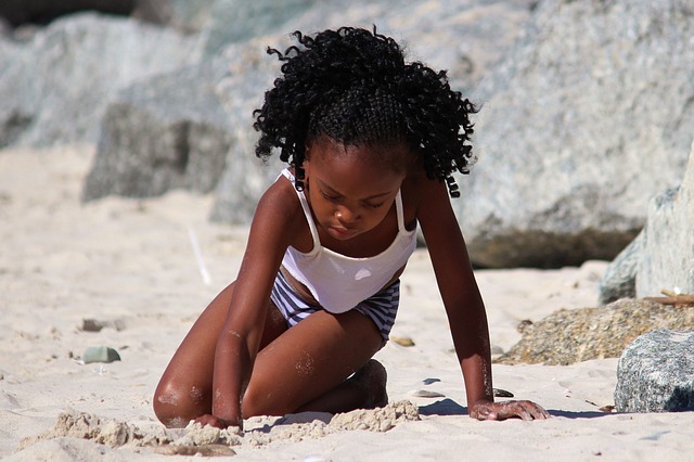 Black girl playing in sand