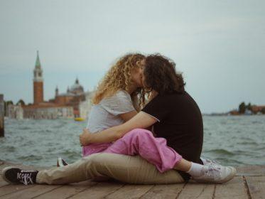 Female and male teens making out near water