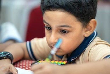 Young boy in class, writing