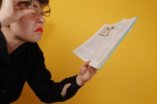 Female teacher frowning, holding papers