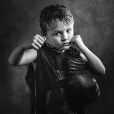 Young boy with arms up, punching toward camera