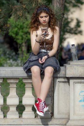 Teen girl on phone, sitting