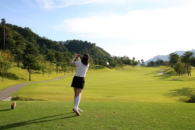 Female teen golfer swinging