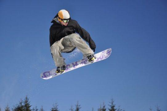 Male teen in air on snowboard