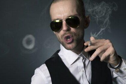 Principal with sunglasses blowing smoke ring