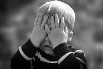 Two year old boy with eyes covered up, black and white photo