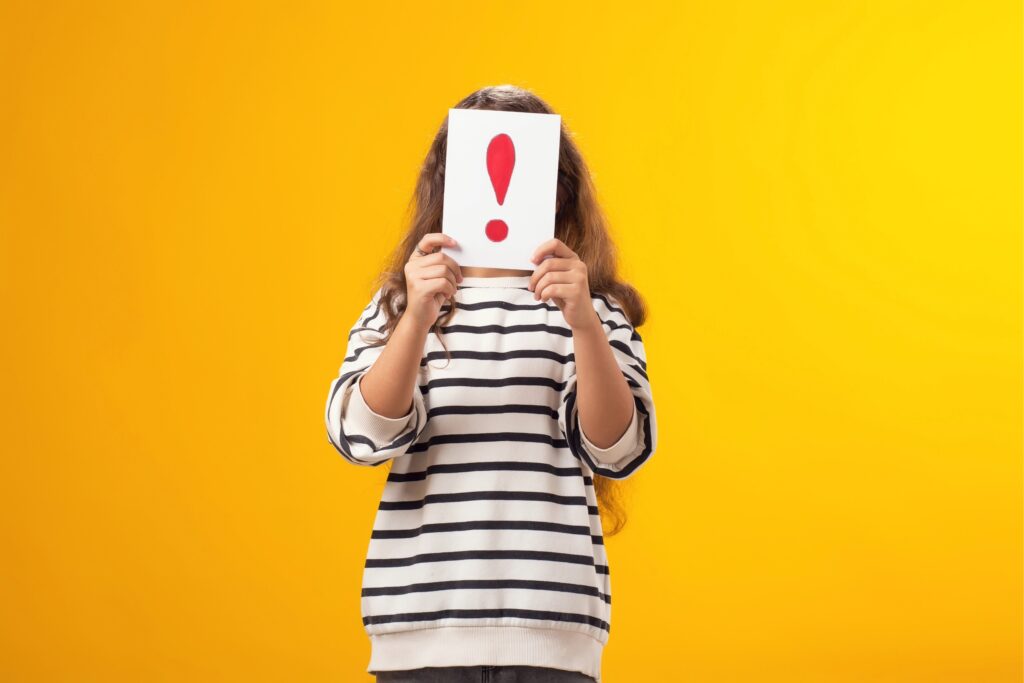 Girl holding up exclamation point