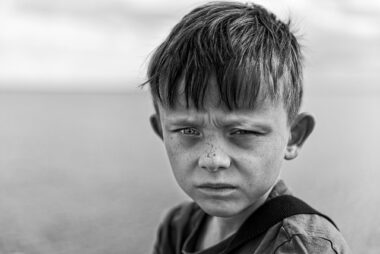 Angry young boy, white, in black and white photo